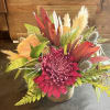A small desk top like arrangement of plum chrysanthemums, Leucadendron, a nude