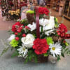 Send Christmas cheer with this lovely basket filled with assorted Christmas greens