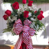 A gorgeous arrangement of a dozen red roses in a metallic red