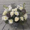 The adorable holiday bouquet is filled with pure white flowers, mixed pine