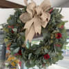 Seasonal wreath arranged with eucalyptus and a bow. (Please order at least