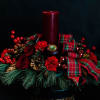 A classic holiday centerpiece with winter pines, berries, cones, red carnations and
