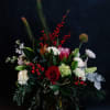 A festive mix of lux holiday blooms designed in  a low