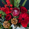 Designer&#039;s choice holiday centerpiece with an assortment of winter pines, cones, berries
