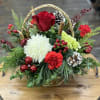Beautiful wicker basket full of fresh holiday greens and flowers