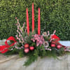 A delightful oblong centerpiece in red and white with 3 tapered candles