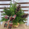 A fragrant mix of seasonal greenery, pine cones and tartan plaid bows