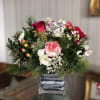 A beautiful mix of winter Christmas greenery, red and white flowers and