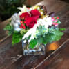 A European style bouquet with Christmas greens, red roses, hydrangea and ribbon