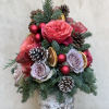 Fresh tabletop Christmas foliage adorned in real roses, pinecones, ribbon and baubles.