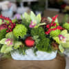 Gorgeous green and red centerpiece arrangement in modern vase vase 