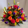 A mixture of seasonal favorites featuring orange roses, hot pink carnations, with