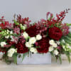 This lovely arrangement is made with lush red peonies and orchids and
