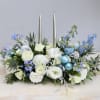 This holiday centerpiece is made with white florals with touches of blue