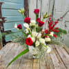 Dramatic arrangement featuring red and white contrast accened with berries and seasonal