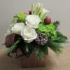 A beautiful arrangement of seasonal colored flowers and Christmas greens all nicely