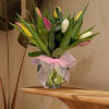 A clear vase filled with assorted tulips and greenery. Simple and beautiful