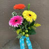 3 gerbera in a budvase with a holiday accent