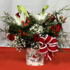This holiday bouquet features red roses, white lilies, red hypericum berries, baby&#039;s