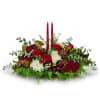 An oblong arrangement filled with seasonal greens and eucalyptus accented with red