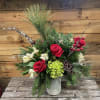 Bursting with pine branches, stunning red roses, and accented with icy glass