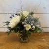 A petite arrangement featuring white roses, brunia berries, and white chrysanthemums in
