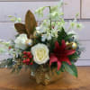 An arrangement of white roses, white orchids, burgundy asiatic lilies, and red