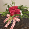 A square vessel filled with fragrant pines, 4 pave&#039; red roses and