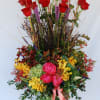 A grand arrangement of long stem red roses, hydrangeas, orchids, peonies, liatris