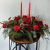 Seasonal red flowers arranged into a holiday centerpiece. (candles included)