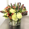 The arrangement features a vibrant mix of lime green garden roses, reddish-orange
