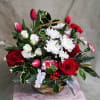 Roses, Tulips, Chrysanthemums, Carnations, Holly &amp; more in a brown basket.