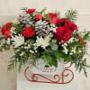 White sleigh with a mix of red florals, pine cones and white
