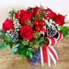Red vase with half dozen roses, babies breath, pine cones, holiday ribbon