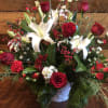 Arrangement in a Basket Filled with Seasonal Evergreens and Fresh Flowers