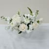 A soft design in a low vase, with crisp white flowers and