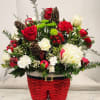 A mixture of seasonal greens and flowers in reds. Whites, and greens