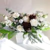 A beautiful winter white centerpiece with playa blaya roses and winter pinecones