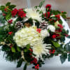Enjoy a holiday themed display of hydrangeas, roses, mums, pinecones and seasonal