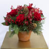 Mix of red flowers including roses, alstroemerias, red berries accented by 
evergreens
