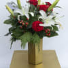 Mix of red and white flowers with winter greens in gold metal