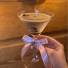 A delectable scented candle in a cozy martini glass with a colored