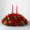 Beautiful all red flowers and candle centerpiece adorned with ribbons and pinecones.