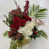 Holiday modern flower arrangement in a square golden vase. A great Christmas