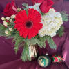 Red and white blossoms arranged in a gold mercury glass vase with