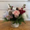 Pale pink roses, magenta stock, white chrysanthemums and seasonal evergreens arranged in