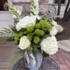 A new design featuring white hydrangeas, snapdragon, roses and more arranged in