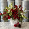 White ceramic vase with red roses, baby roses, snapdragons, amaryllis and some