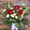 A Mason jar style vase in white with a red cardinal holds