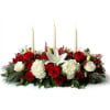 Radiating holiday warmth, this festive centerpiece brings together snowy hydrangeas, velvety red